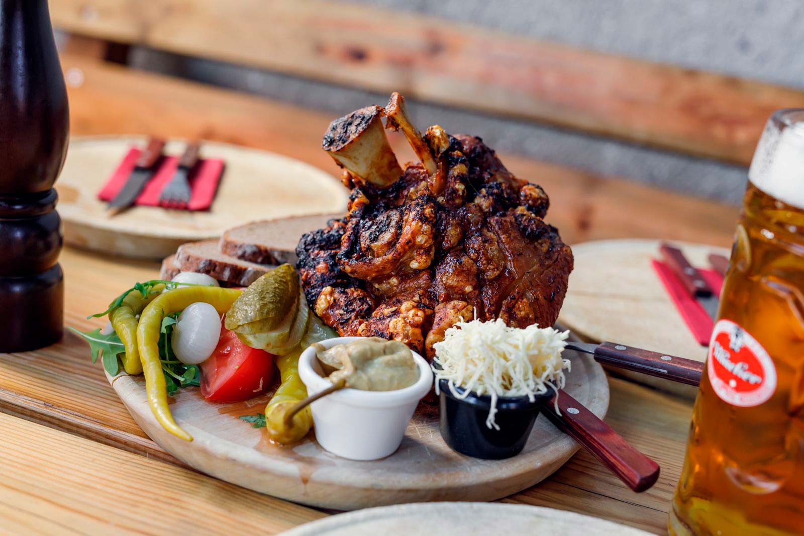Jausen Stelze mit Saurem Gemüse und Brot daneben steht ein Maß Bier